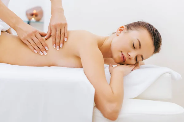 Attraktive junge Frau mit Massage im Wellnessbereich — Stockfoto