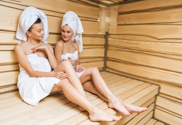 Belas mulheres jovens sentadas no banco na sauna — Fotografia de Stock