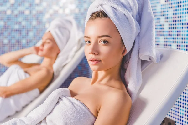 Mujeres jóvenes relajándose en tumbonas en el centro de spa - foto de stock