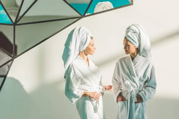 Hermosas mujeres jóvenes en albornoces en el centro de spa - foto de stock