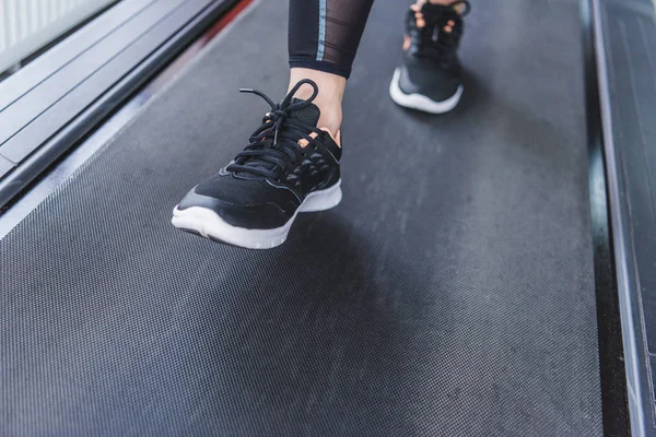 Обрізаний знімок жінки в сучасних кросівках, що працюють на біговій доріжці — стокове фото