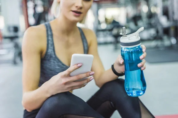 Schnappschuss von Frau mit Smartphone im Fitnessstudio — Stockfoto