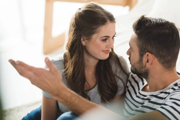 Glückliches junges Paar spricht zu Hause miteinander — Stockfoto