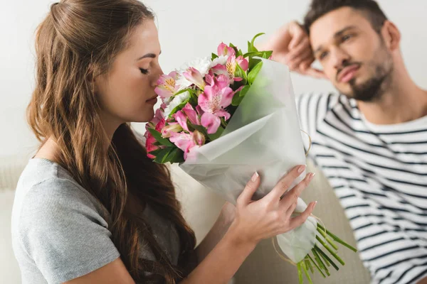 Young woman with beautiful bouquet presented by boyfriend — Stock Photo