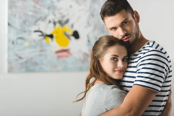 Jovem belo casal abraçando e olhando para a câmera — Fotografia de Stock