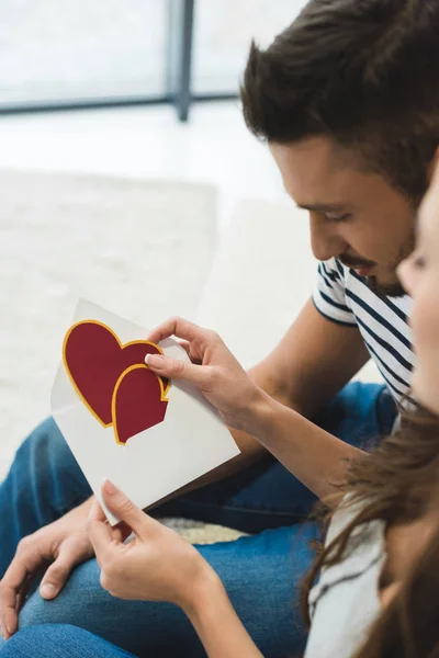 Close-up shot of young couple with valentines day greeting card in envelope — Stock Photo