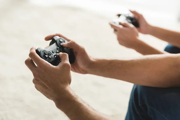 Tiro recortado de casal jogando jogos de computador com gamepads — Fotografia de Stock