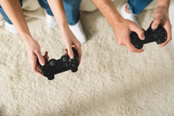 Vue de dessus du couple jouant à des jeux d'ordinateur avec des manettes — Photo de stock