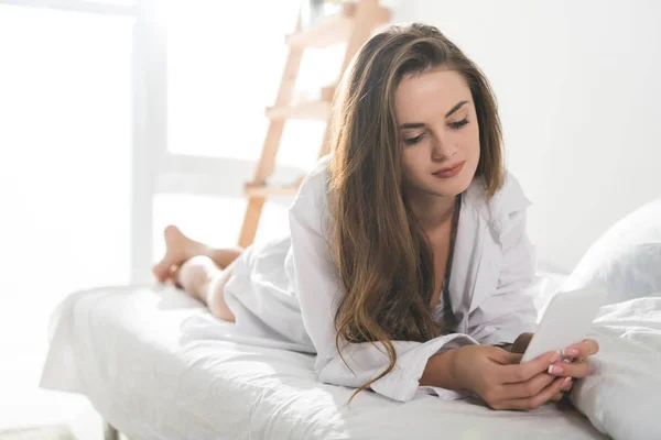 Beautiful young woman using smartphone in morning — Stock Photo
