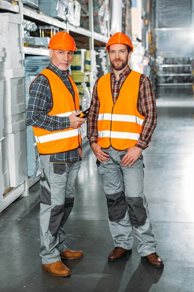 Dos trabajadores masculinos sosteniendo walkie talkie en stock de envío - foto de stock