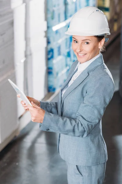 Inspetor fêmea no capacete usando tablet digital no armazenamento — Fotografia de Stock