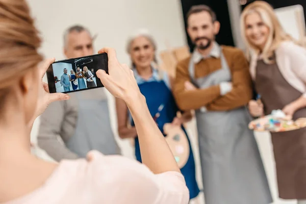 Обрізаний знімок жінки зі смартфоном, який фотографує дорослих студентів мистецького класу — стокове фото