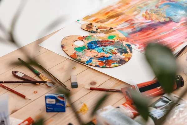 Selektiver Fokus der Palette mit Farben und Kunstwerkzeugen auf dem Tisch — Stockfoto