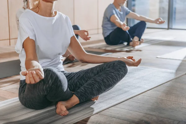 Seniorengruppe praktiziert Yoga mit Instruktor in Lotus-Pose auf Matten im Studio — Stockfoto
