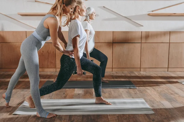 Gruppe älterer Frauen praktiziert Yoga mit Instruktor auf Matten im Studio — Stockfoto