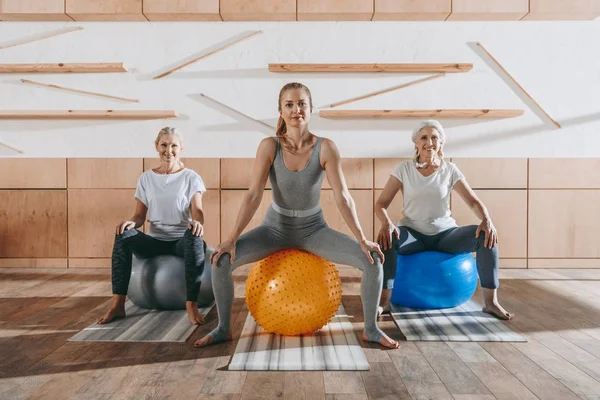 Gruppo di donne che si esercitano con le palle fitness in studio — Foto stock