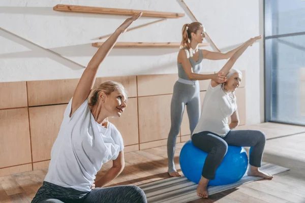 Grupo de personas mayores haciendo ejercicio con pelotas de fitness en el estudio - foto de stock