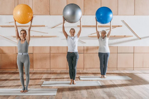 Grupo de personas mayores haciendo ejercicio con pelotas de fitness en el estudio - foto de stock