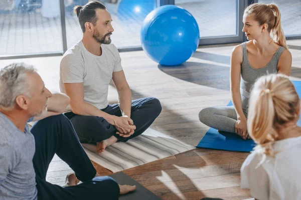 Senior people with instructor exercising together on yoga mats — Stock Photo