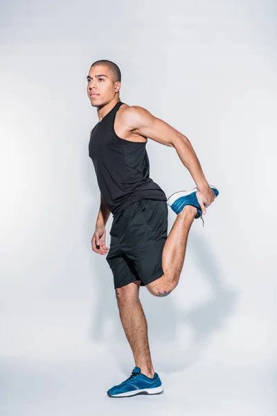 Africano americano sportivo uomo stretching gambe — Foto stock