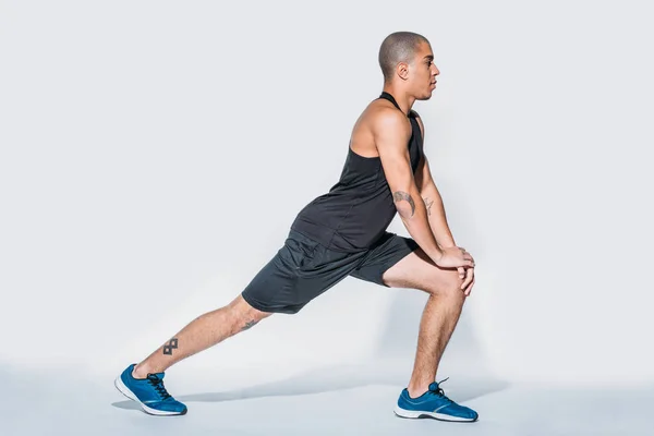 Side view of african american sportsman stretching legs — Stock Photo