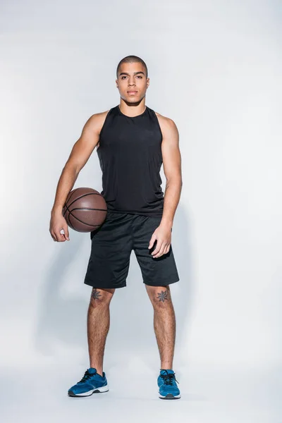 Jugador de baloncesto afroamericano de pie con pelota - foto de stock