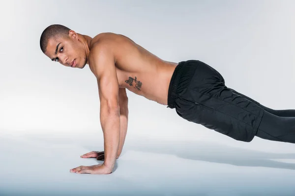 African american sportive man doing push up and looking at camera — Stock Photo