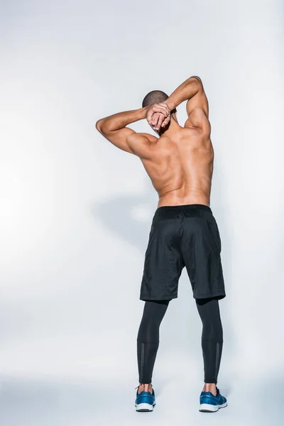 Вид ззаду м'язистий афроамериканський спортсмен розтягує тіло — стокове фото