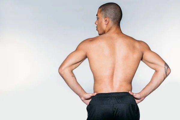 Вид ззаду без сорочки м'язистий афроамериканський спортсмен, що стоїть ізольовано на білому — стокове фото