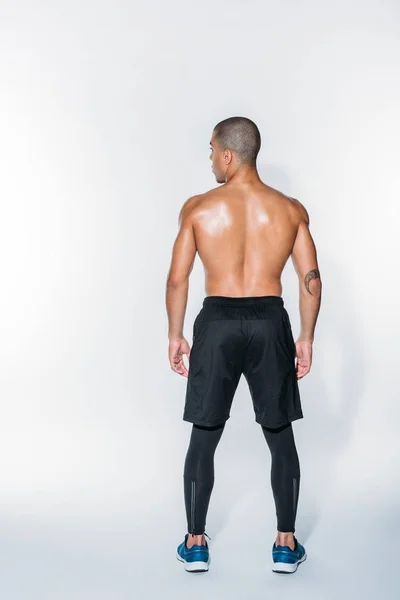 Rear view of sweaty african american sportsman standing on white — Stock Photo