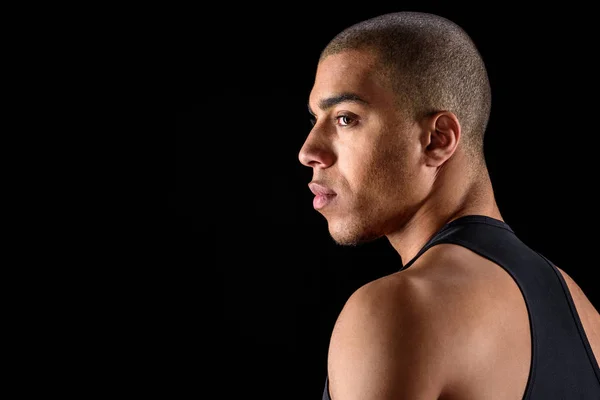 Side view of african american man looking away isolated on black — Stock Photo