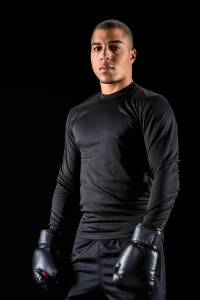 Спортивний афроамериканський боксер в чорному спортивному одязі ізольовано на чорному — стокове фото