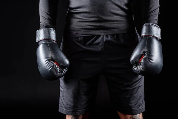 Cropped shot of boxer in black gloves isolated on black — Stock Photo