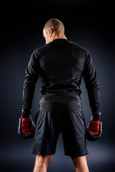 Back view of african american boxer in gloves on black — Stock Photo