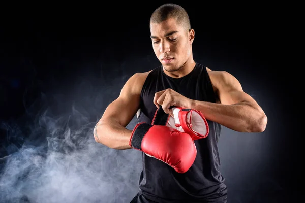 Молодой африканский американский боксер надевает перчатки на черный — стоковое фото