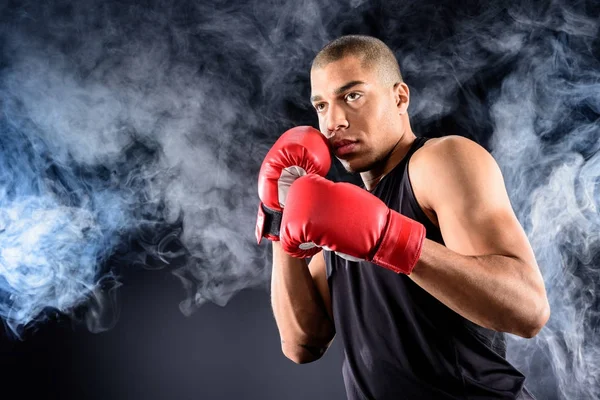 Jeune boxeur afro-américain debout en position de défense sur noir — Photo de stock