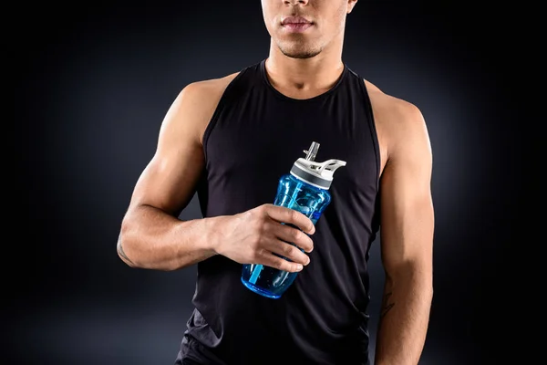 Atleta afro-americano bonito com garrafa de água fitness em preto — Fotografia de Stock