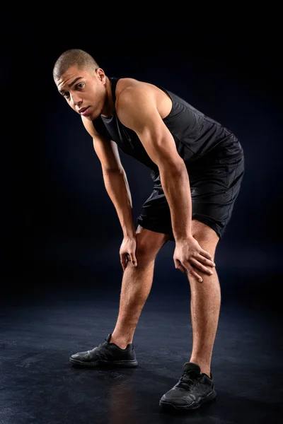 African american sportsman exhausted after workout on black — Stock Photo