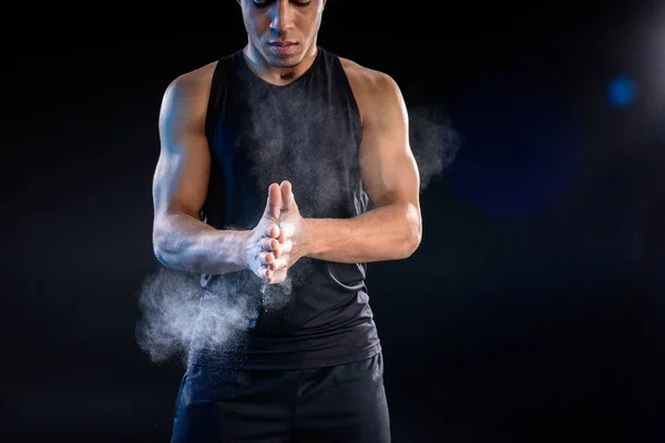 Jeune sportif afro-américain applaudissant les mains avec talc sur noir — Photo de stock