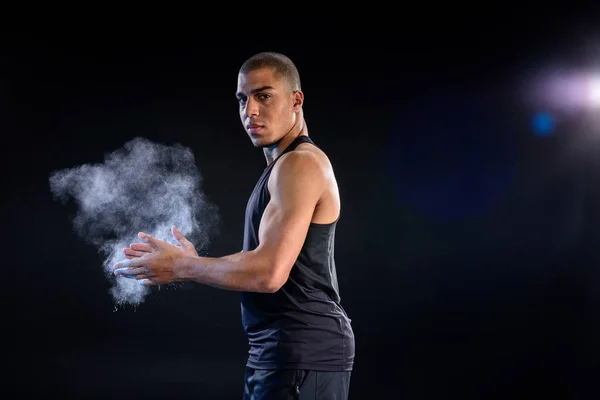 African american sportsman clapping hands with talc on black — Stock Photo