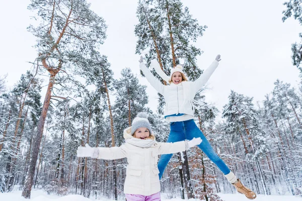 Мать и маленькая дочь веселятся вместе в зимнем парке — стоковое фото