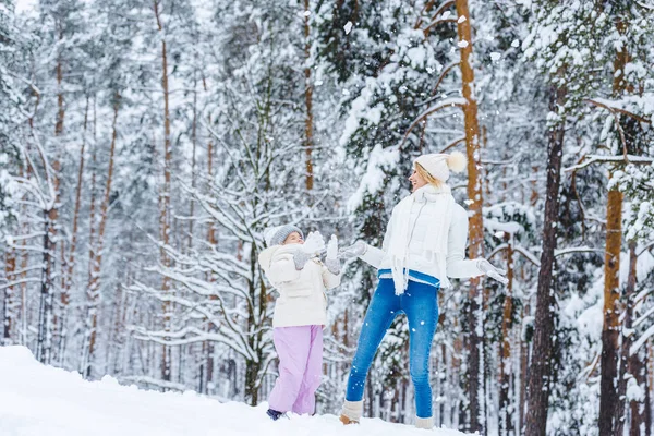 Mutter und kleine Tochter amüsieren sich gemeinsam im Winterpark — Stockfoto
