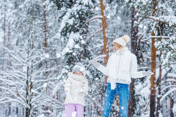 Mother and little daughter having fun together in winter park — Stock Photo