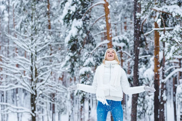 Portrait of cheerful young woman playing with snow in winter park — Stock Photo