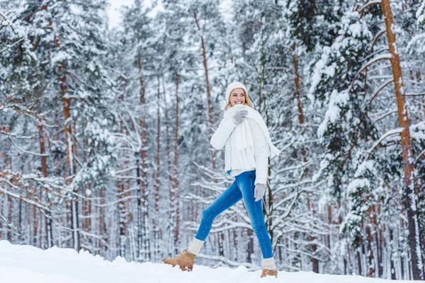 Beautiful young woman walking in winter forest — Stock Photo