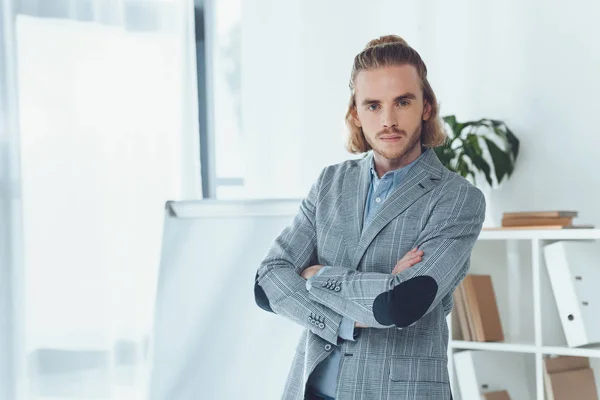 Businessman standing with crossed arms and looking at camera — Stock Photo