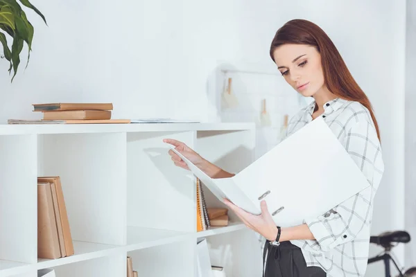 Attrayant femme d'affaires à la recherche de documents dans le dossier — Photo de stock