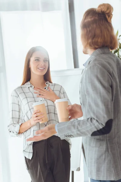 Коллеги-мужчины и женщины разговаривают во время перерыва на кофе в офисе — стоковое фото