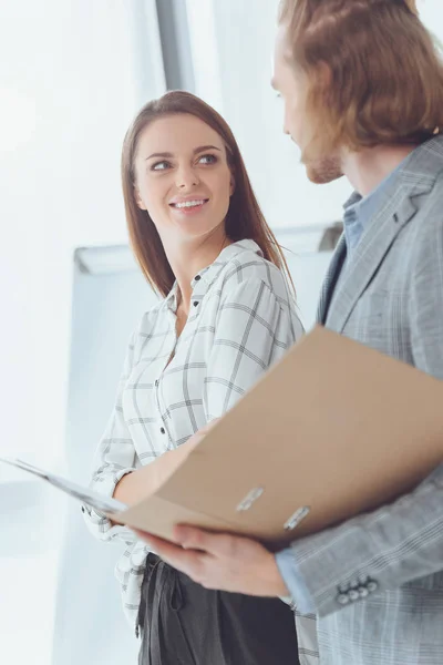 Male and female colleagues with folder with documents — Stock Photo