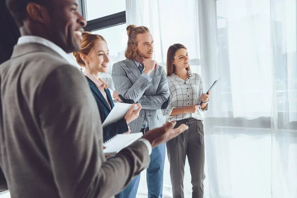 Lächelnde multikulturelle Geschäftsleute, die wegschauen — Stockfoto